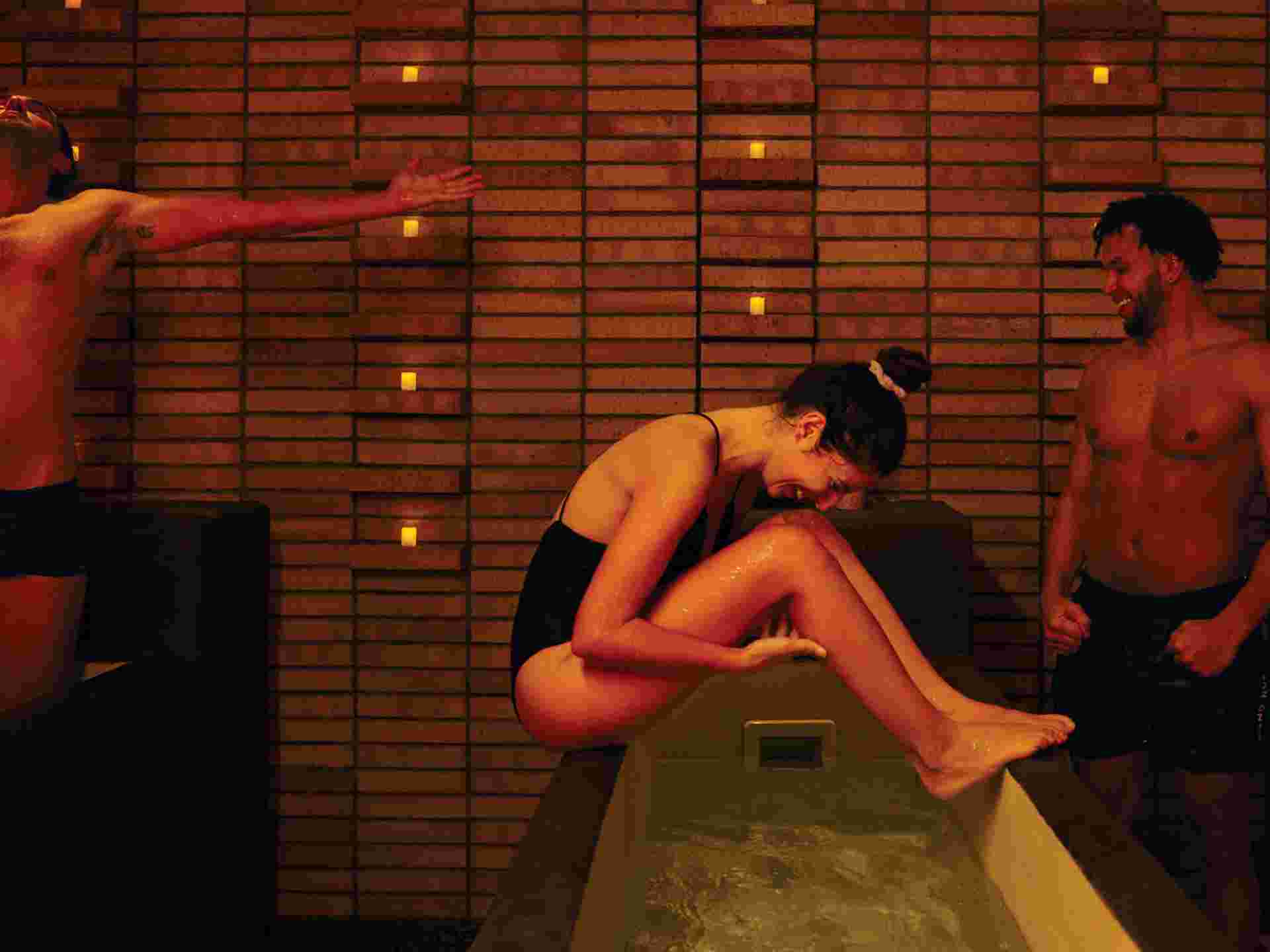 two men and a woman hanging out in the spa, enjoying themselves