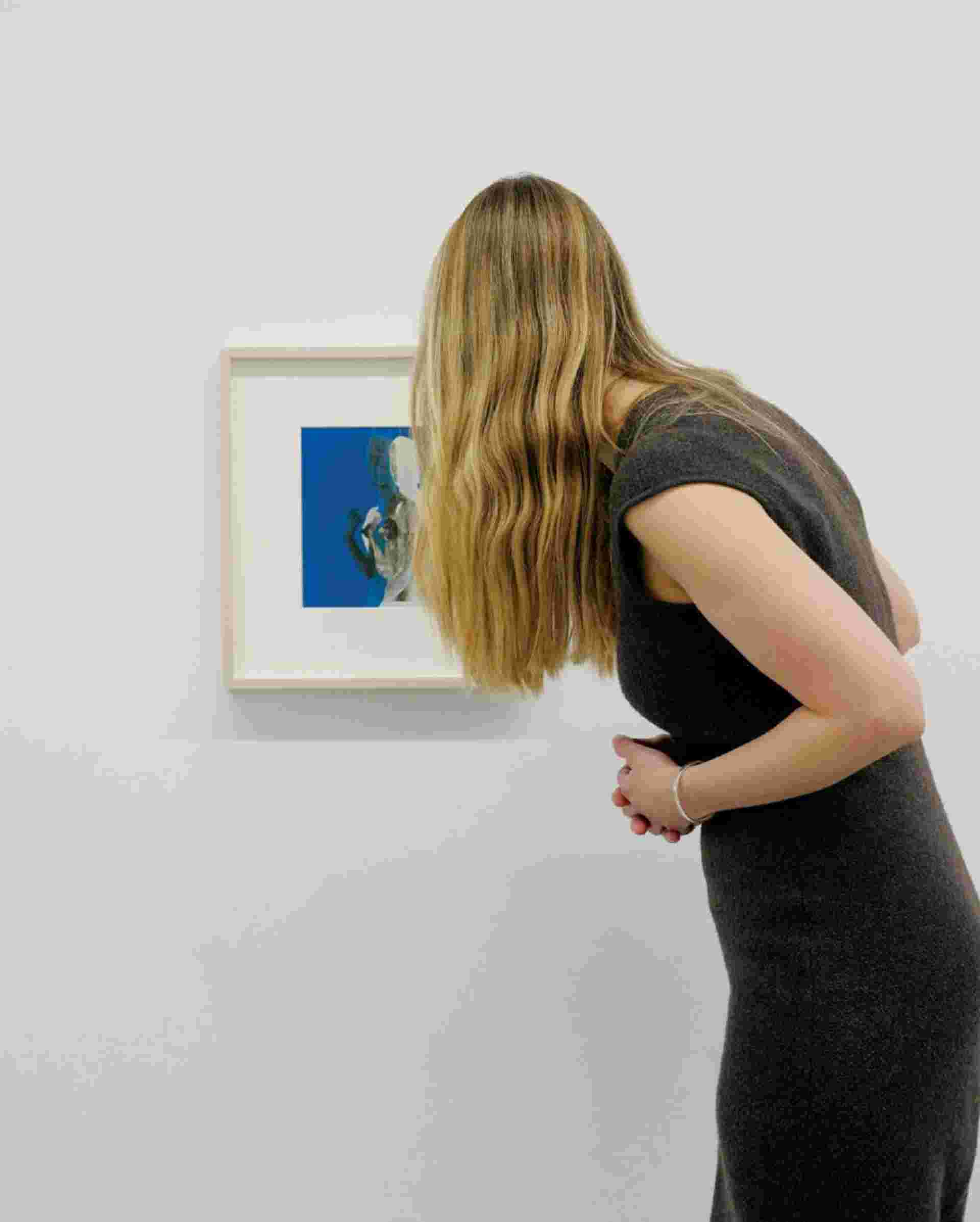 Leanne Shapton - blonde-woman-inspecting-art-on-gallery-wall