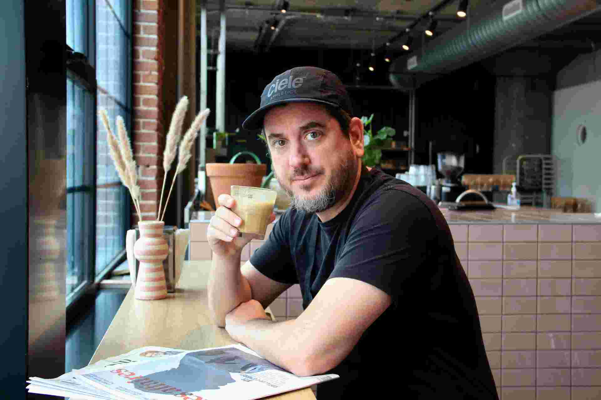 Room for Dessert - 17-Man-sitting-in-a-cafe-holding-a-coffee