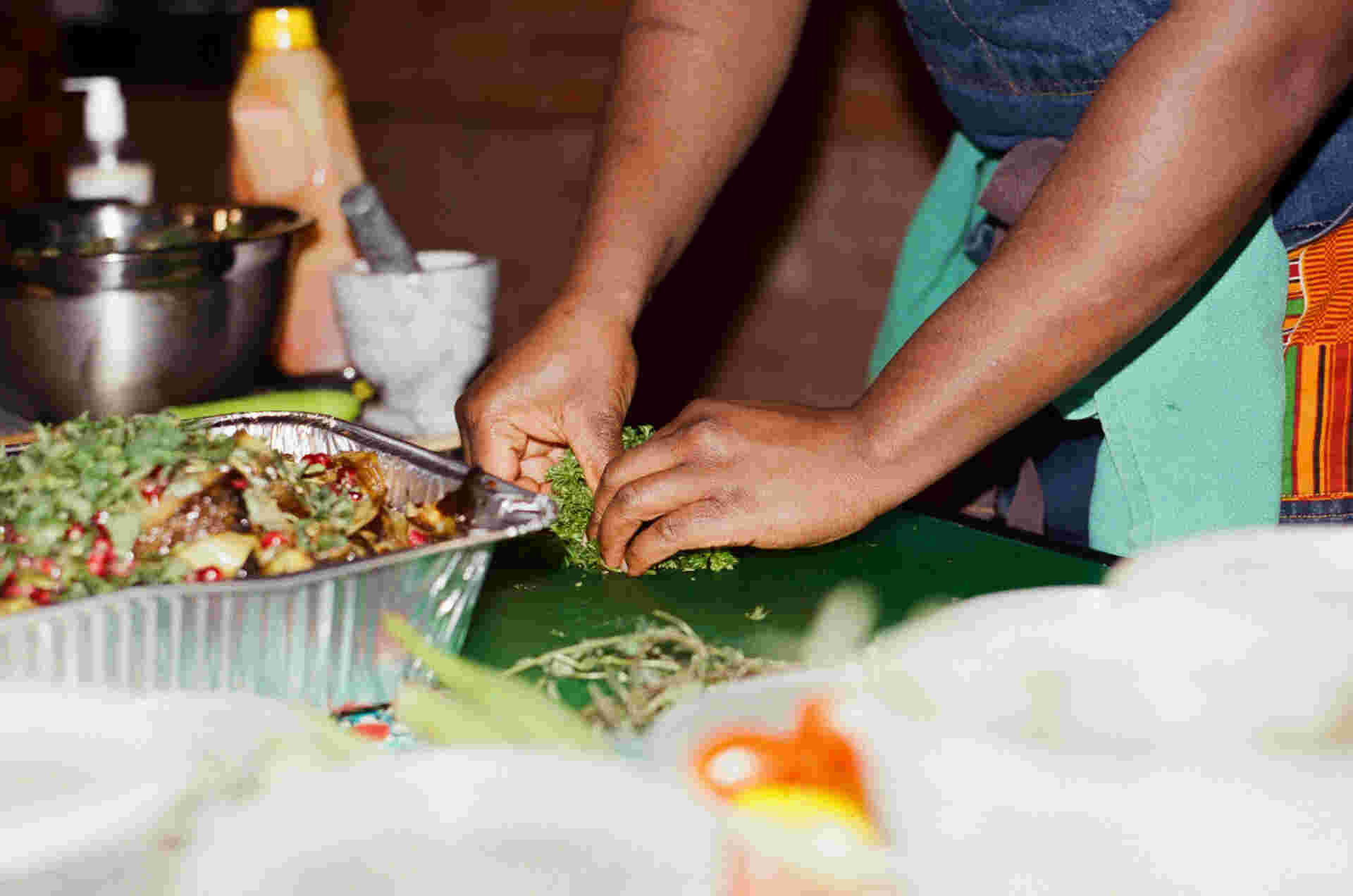 2025-02-11 13:26 EST - 4-hands_plucking_fresh_parsley_next_to_tray_of_roasted_vegetables_with_pomegranate