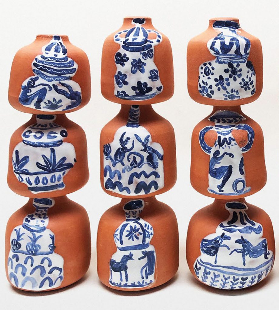Ceramic pots with painted designs stacked on top of each other. 